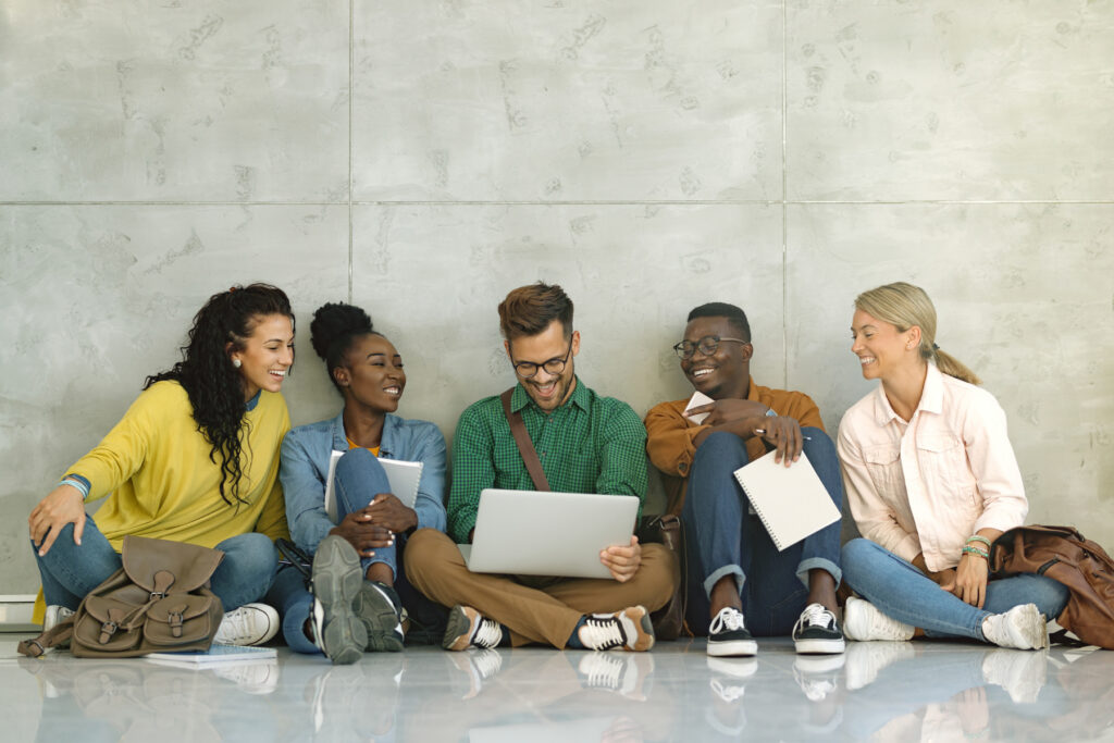 Studierende sitzen mit Laptop zusammen und lernen