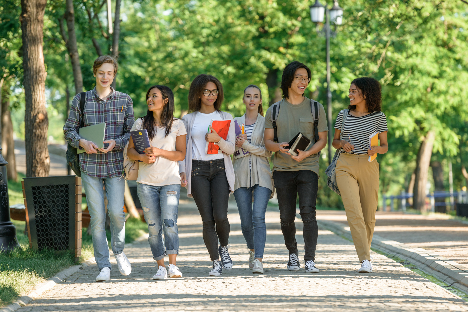 Studierende gehen gemeinsam über einen Campus
